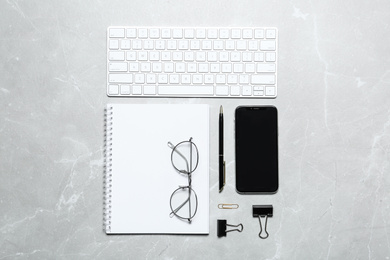 Photo of Flat lay composition with computer keyboard and smartphone on marble background