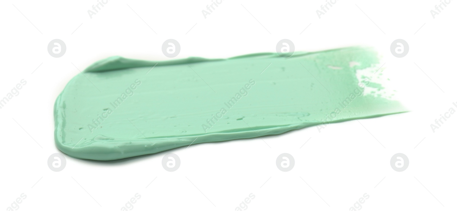 Photo of Stroke of green color correcting concealer on white background