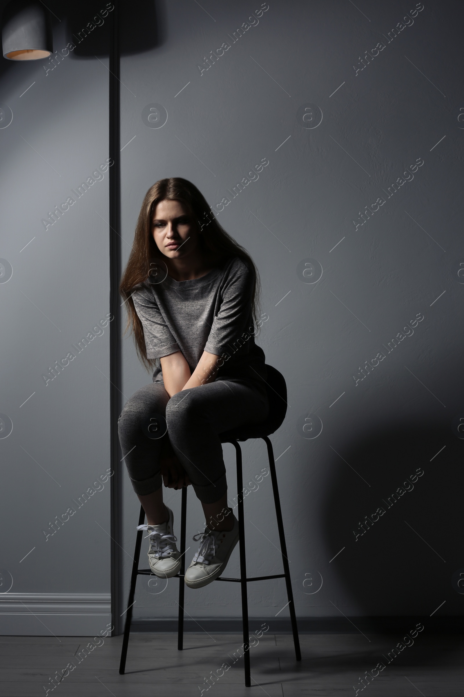 Photo of Depressed young woman on gray background