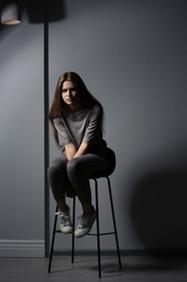Photo of Depressed young woman on gray background