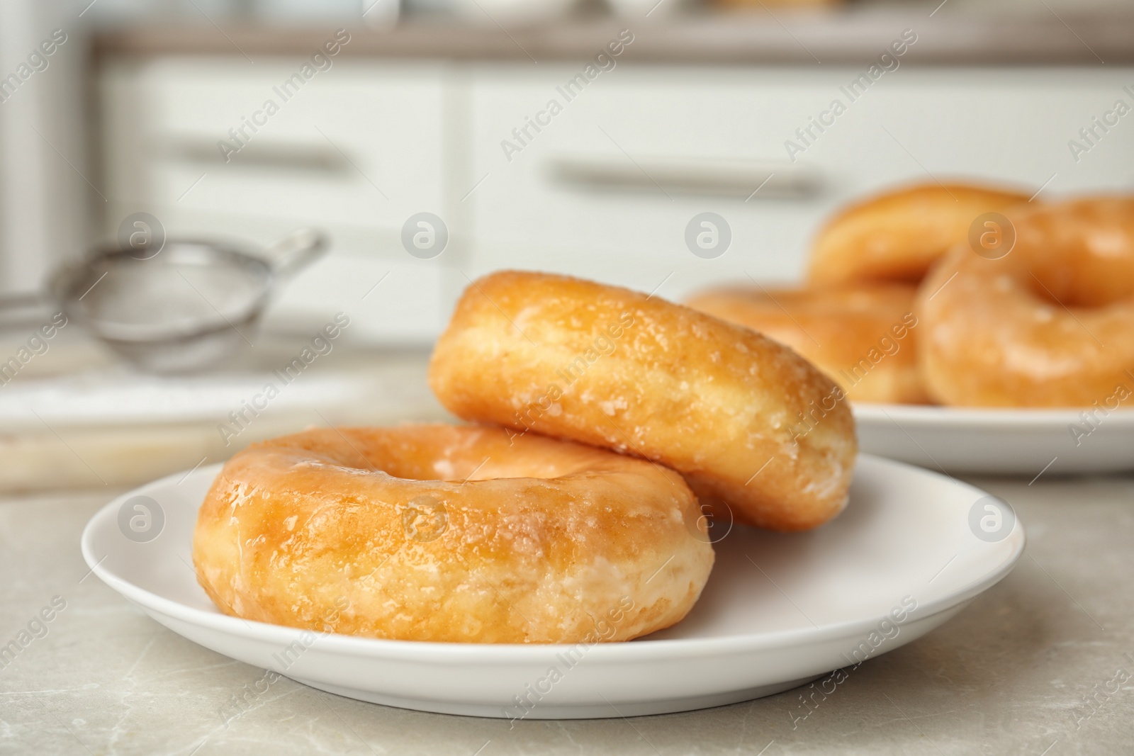 Photo of Sweet delicious glazed donuts on light table