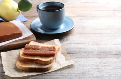 Tasty sandwich with quince paste served for breakfast on wooden table, space for text