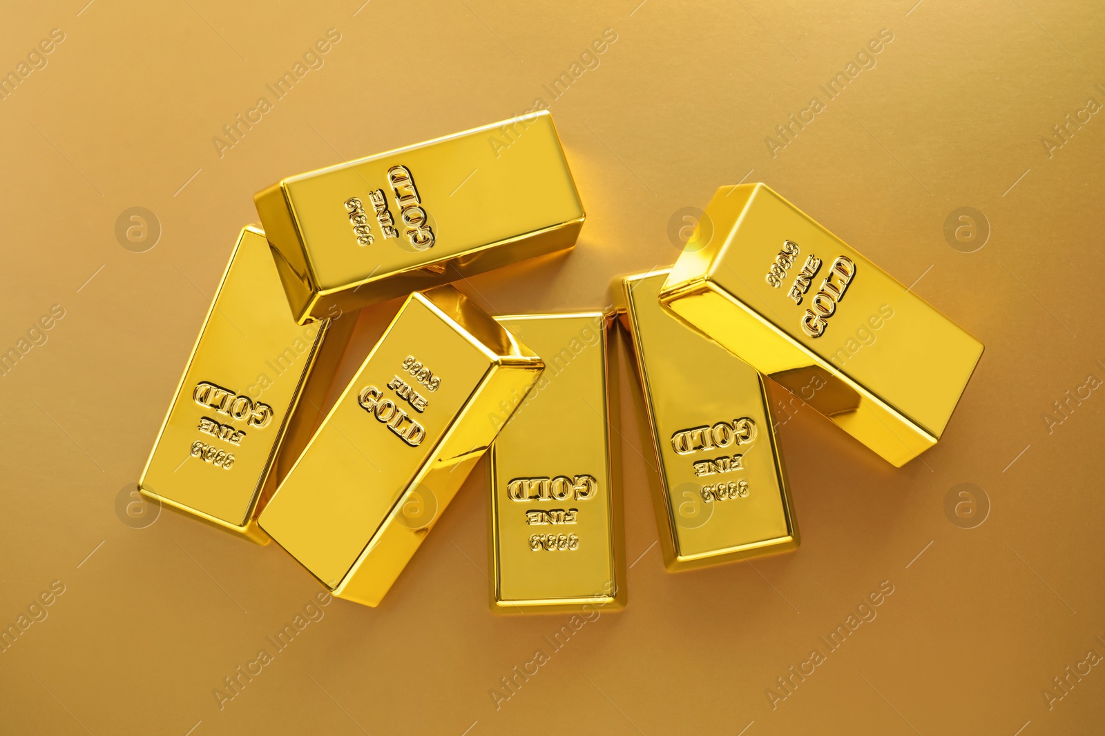 Photo of Shiny gold bars on color background, flat lay