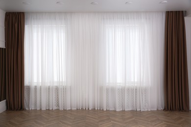 Photo of Windows with elegant curtains in room. Interior design