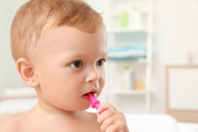 Cute little boy with toothbrush on blurred background