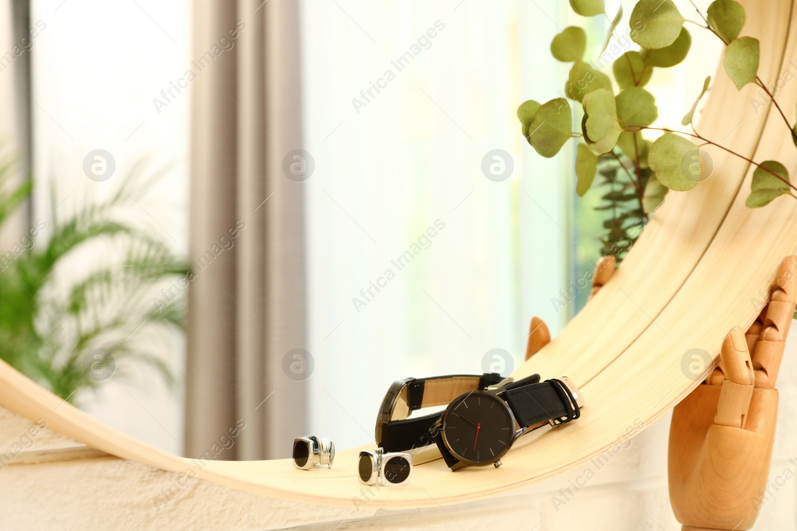 Photo of Round mirror with male accessories on brick wall indoors, closeup. Interior design