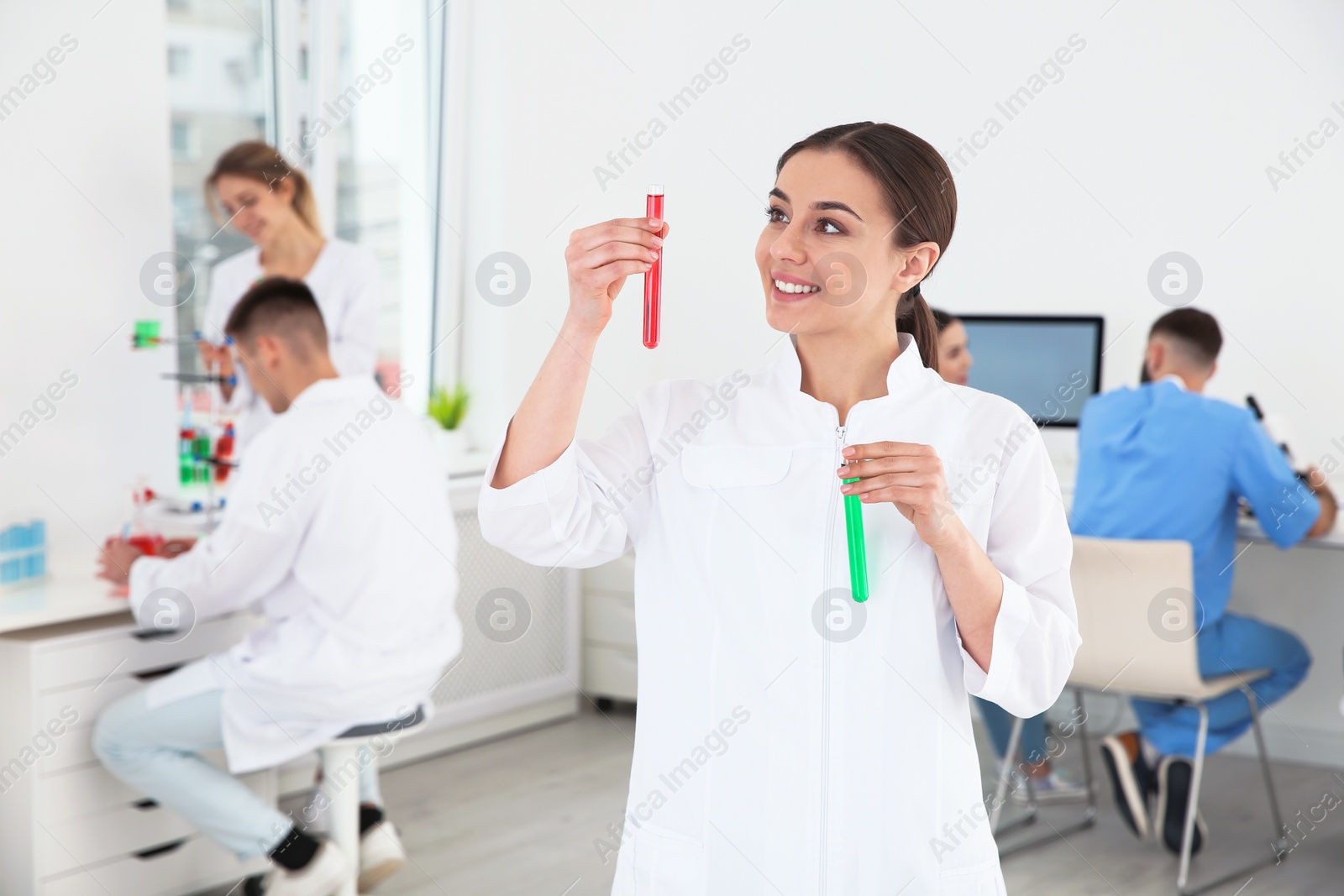 Photo of Portrait of medical student with test tubes in modern scientific laboratory