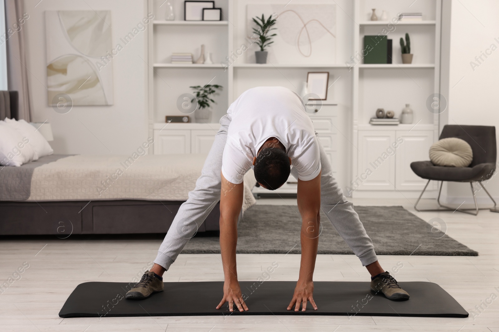 Photo of Man doing morning exercise on fitness mat at home