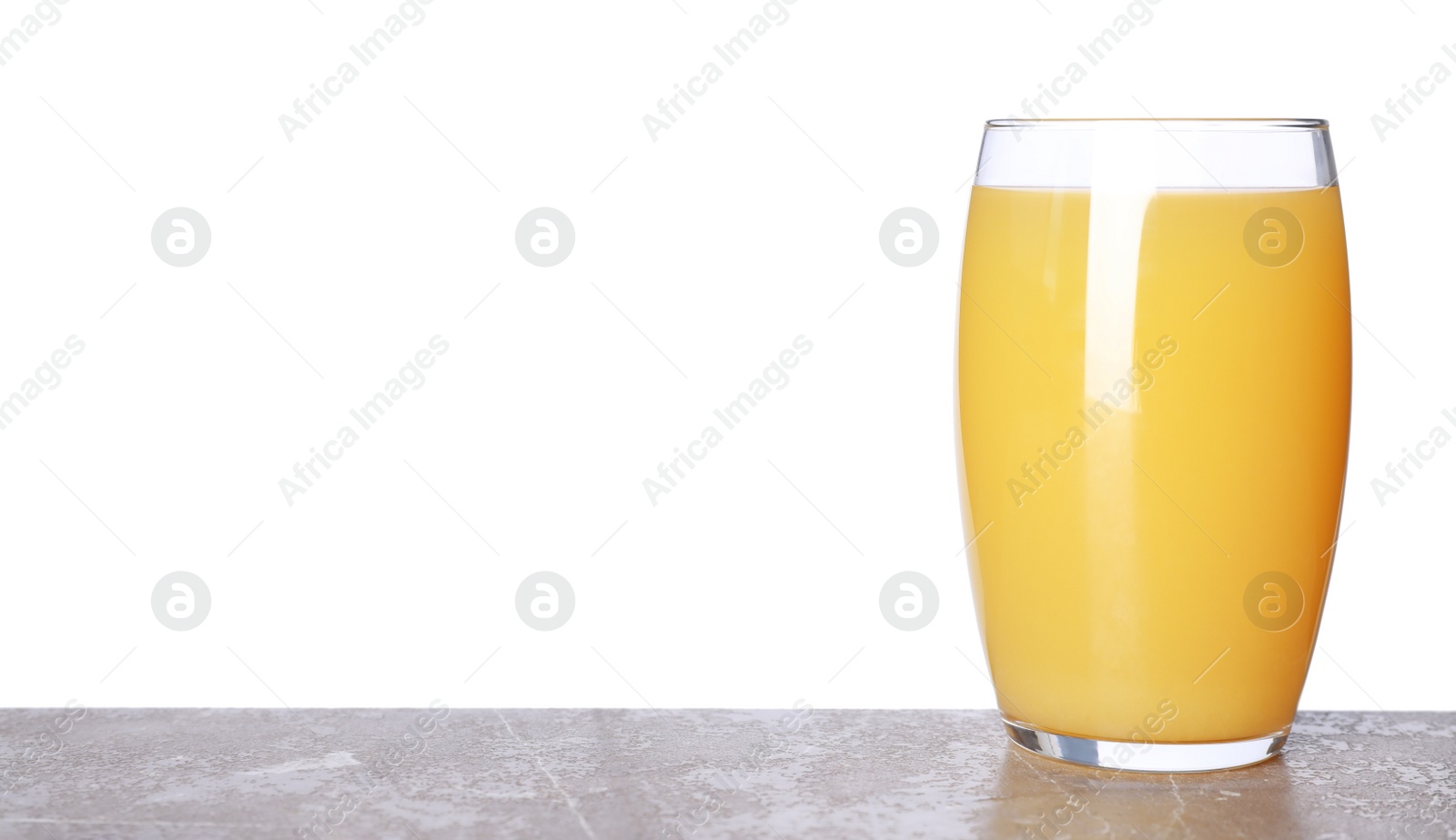 Photo of Glass of delicious juice on grey table against white background