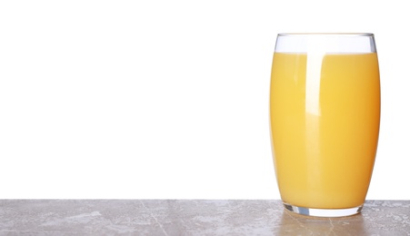 Photo of Glass of delicious juice on grey table against white background