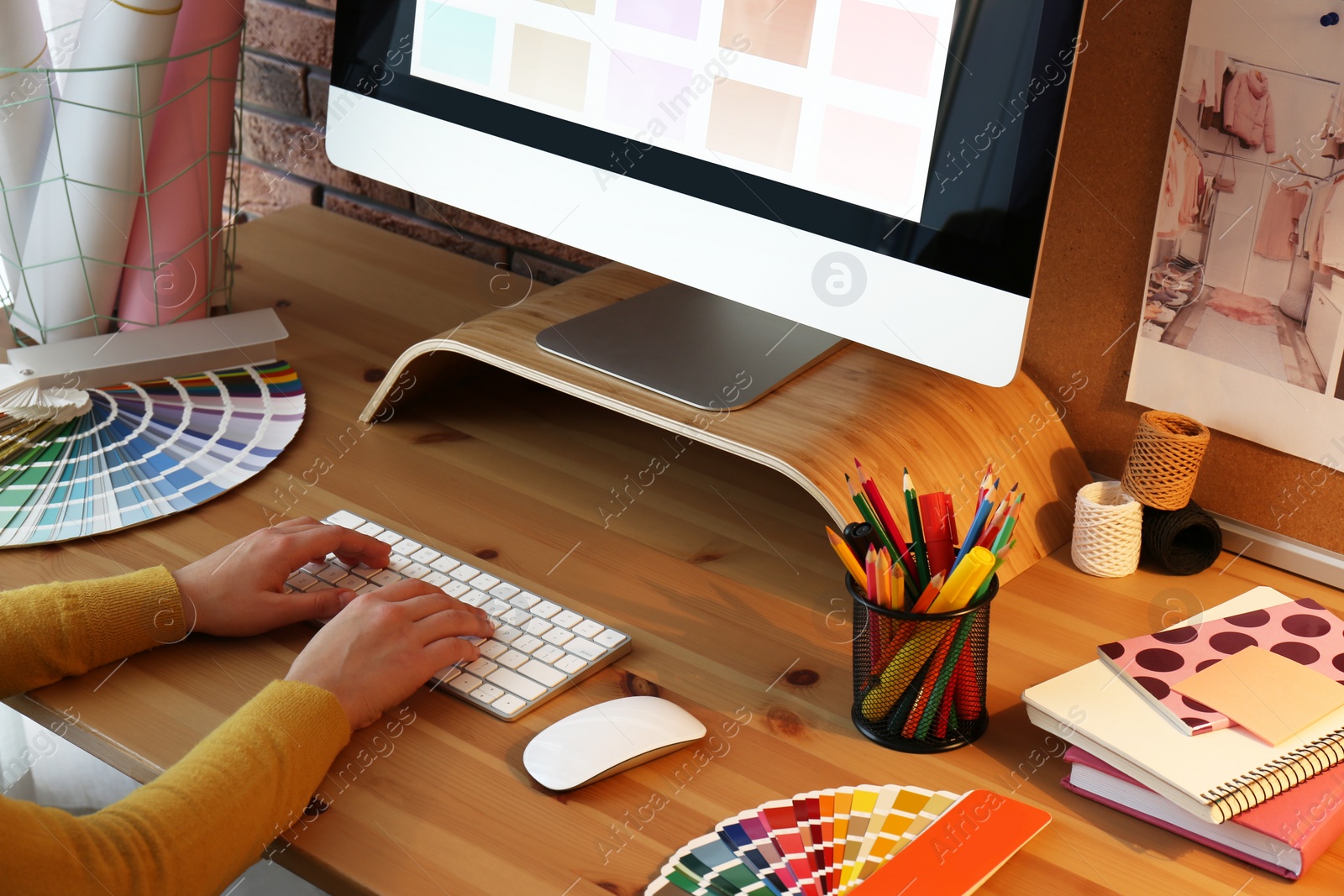 Photo of Designer working with computer at wooden table, closeup