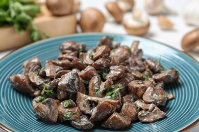 Photo of Plate of tasty fried mushrooms with sauce on table, closeup