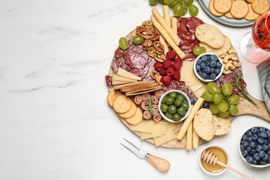 Photo of Tasty parmesan cheese and other different appetizers on white marble table, flat lay. Space for text
