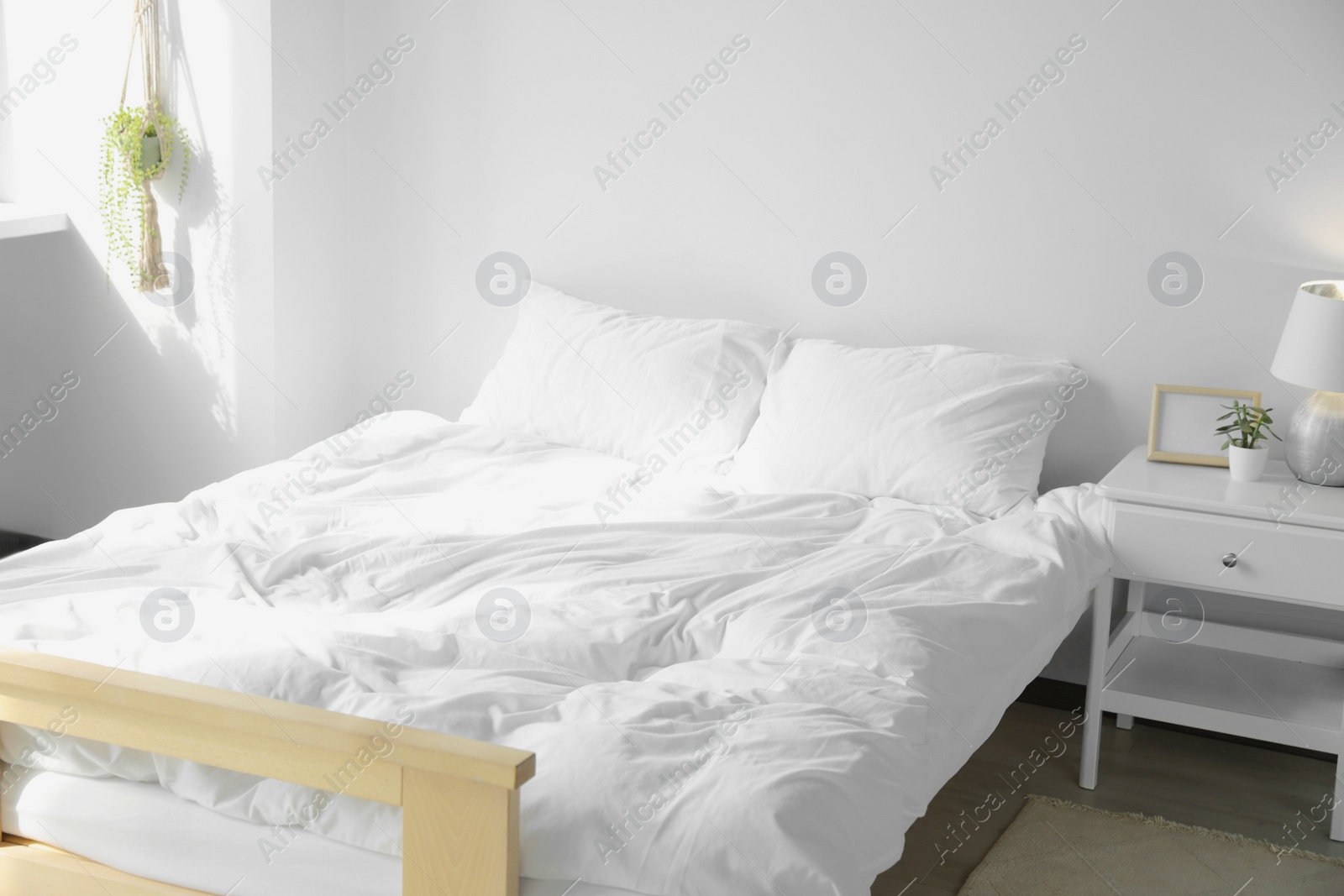 Photo of Large comfortable bed with soft pillows and blanket indoors