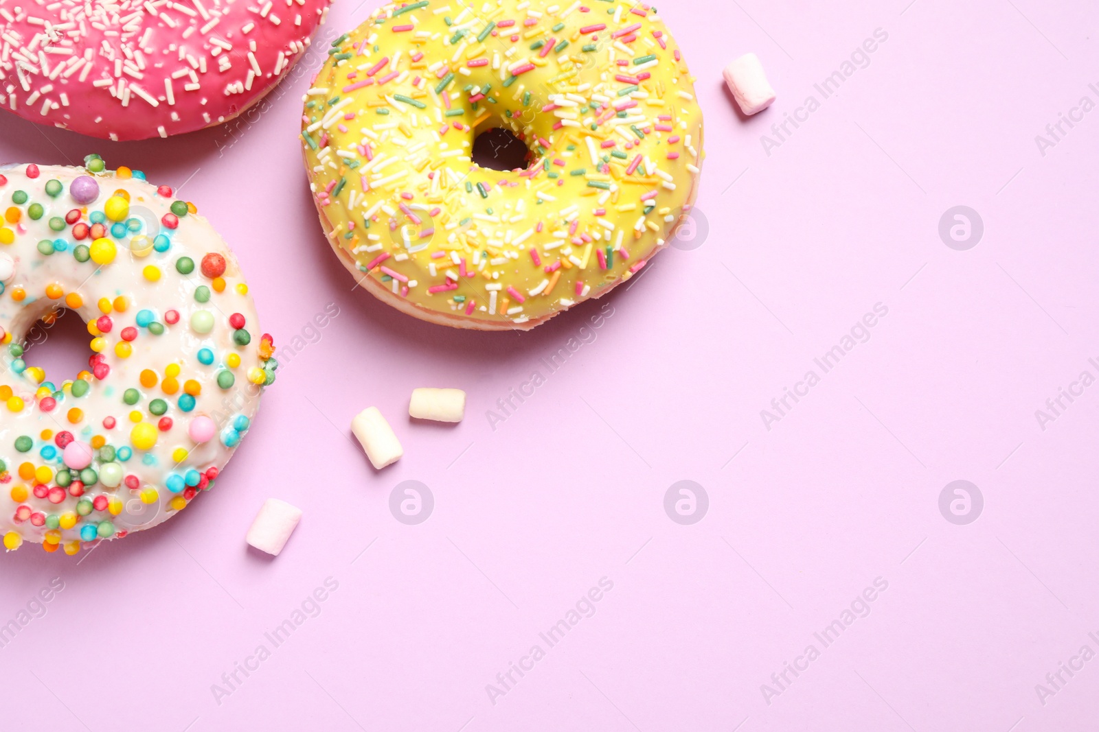 Photo of Delicious glazed donuts on lilac background, flat lay. Space for text