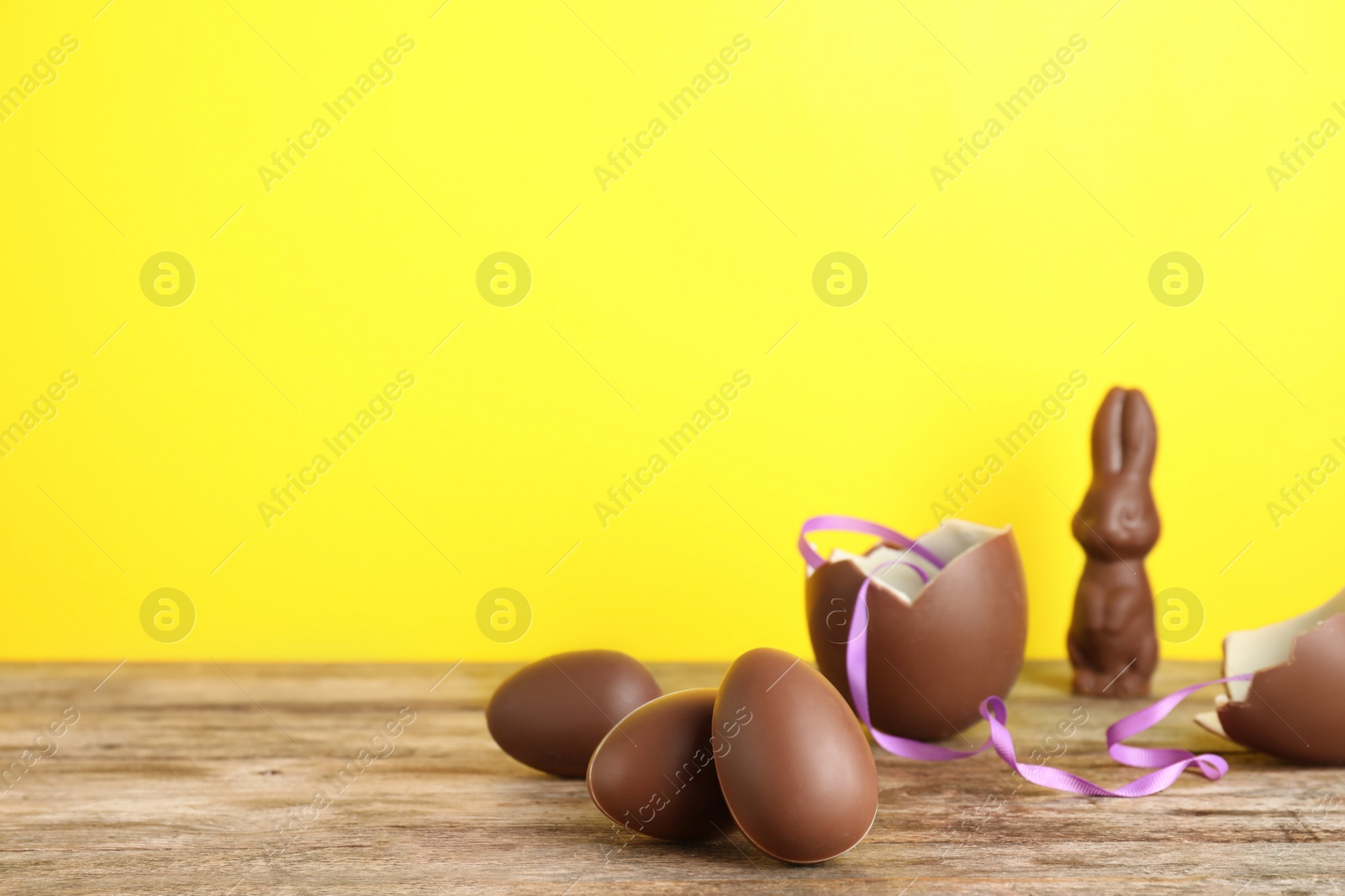 Photo of Beautiful composition with chocolate Easter eggs on wooden table. Space for text