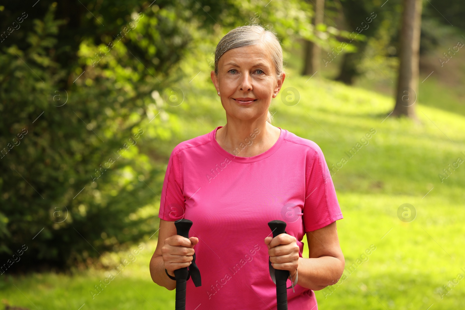 Photo of Senior woman with Nordic walking poles outdoors