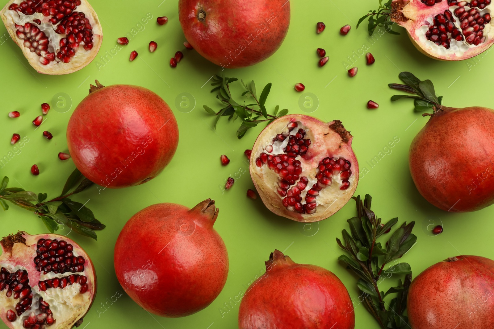 Photo of Flat lay composition with ripe pomegranates on green background