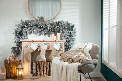 Fireplace with Christmas stockings in festive room interior