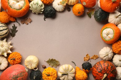 Frame made of different ripe pumpkins and dry leaves on light grey background, flat lay. Space for text