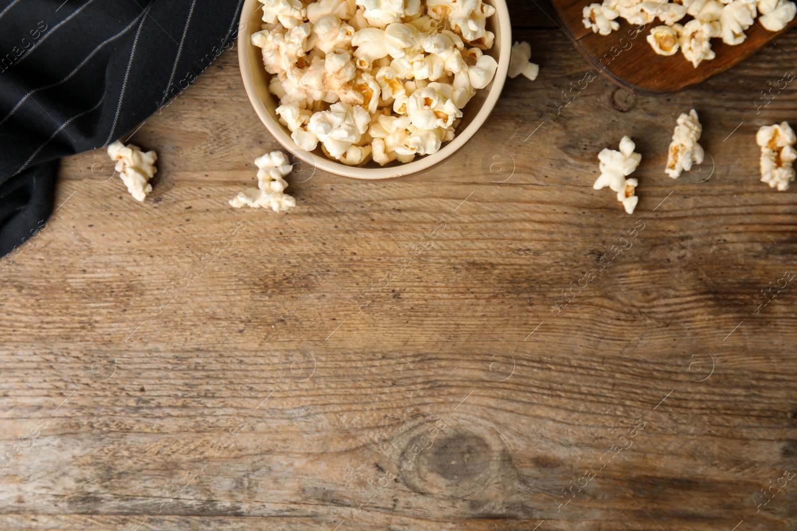 Photo of Tasty pop corn on wooden table, flat lay. Space for text