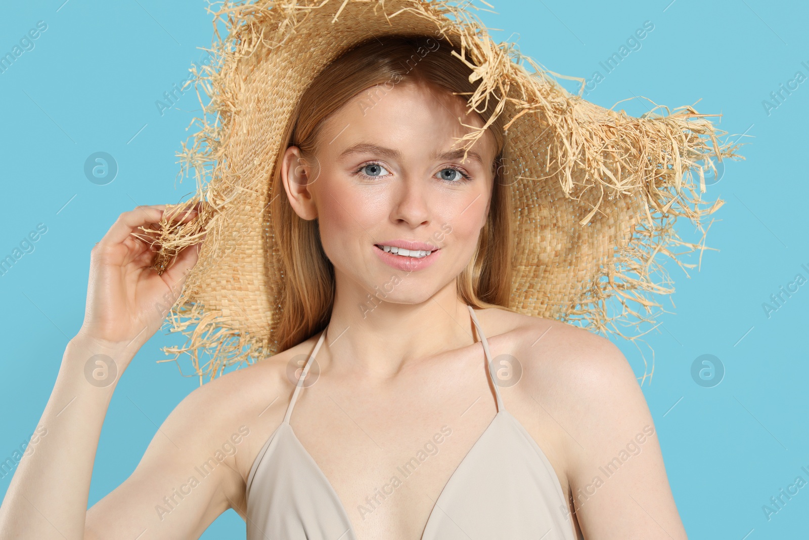 Photo of Beautiful young woman in straw hat on light blue background