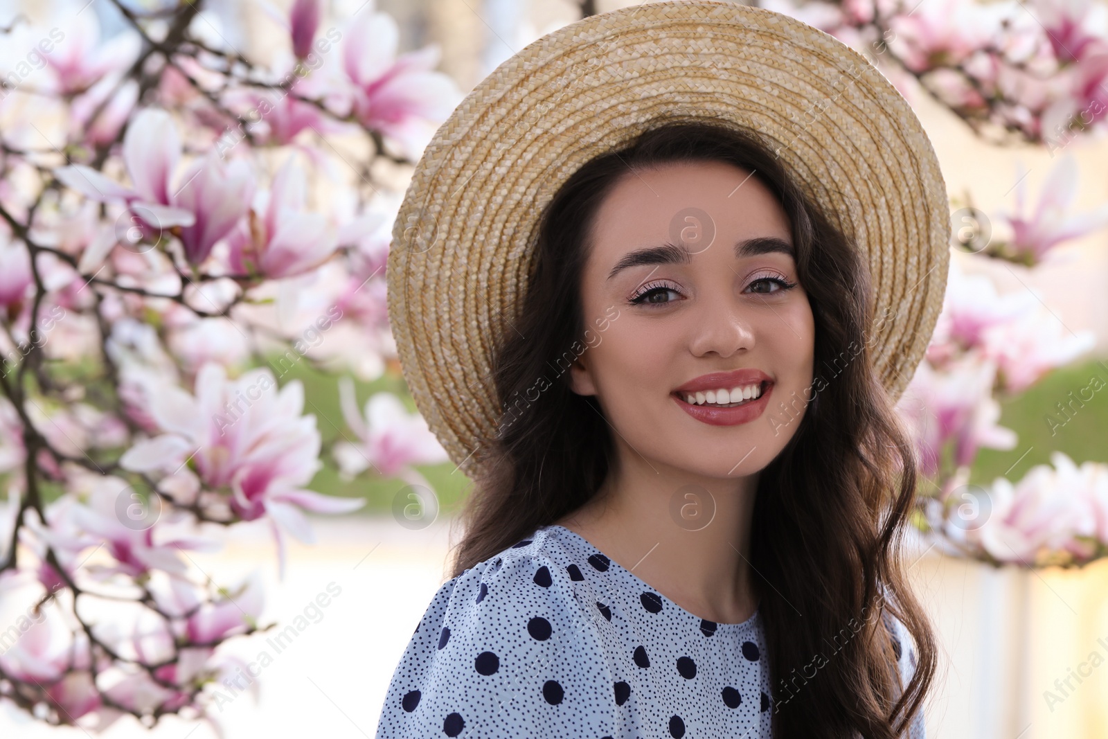 Photo of Beautiful woman near blossoming magnolia tree on spring day