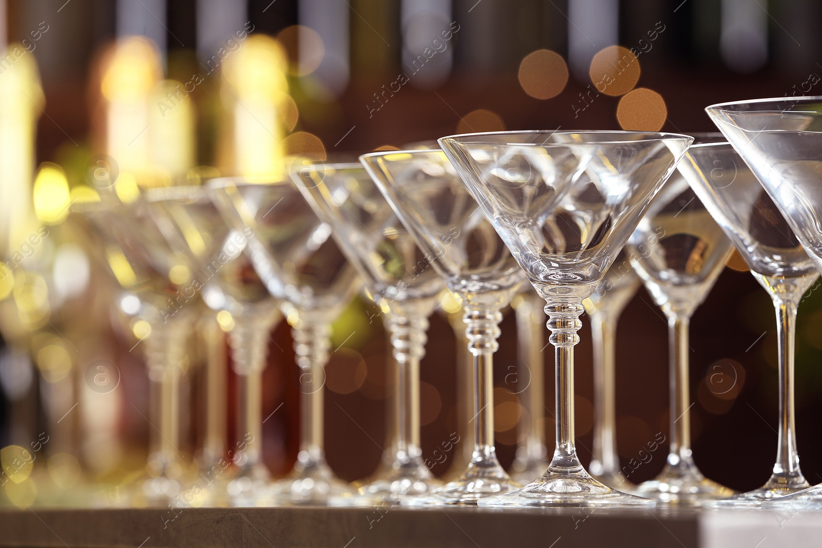 Photo of Empty martini glasses on table against blurred background