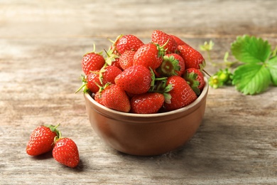 Photo of Bowl with fresh ripe strawberries on wooden table