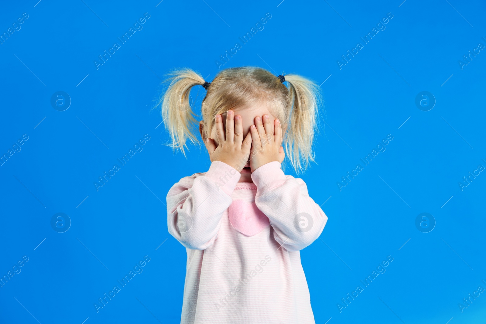 Photo of Cute little girl posing on light blue background
