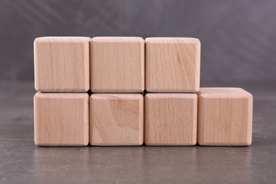 Photo of Wooden cubes with abbreviation ISO and number 9001 on grey textured table
