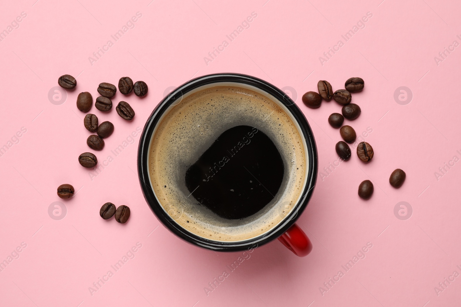 Photo of Fresh coffee in cup and roasted beans on pink background, top view
