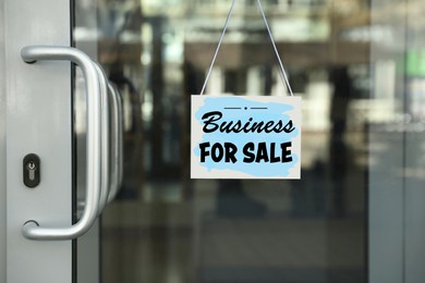 Image of Light blue sign with Business For Sale hanging on glass door