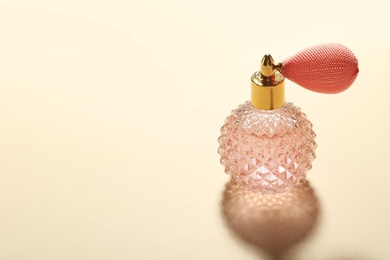 Elegant vintage bottle of perfume on beige background, space for text