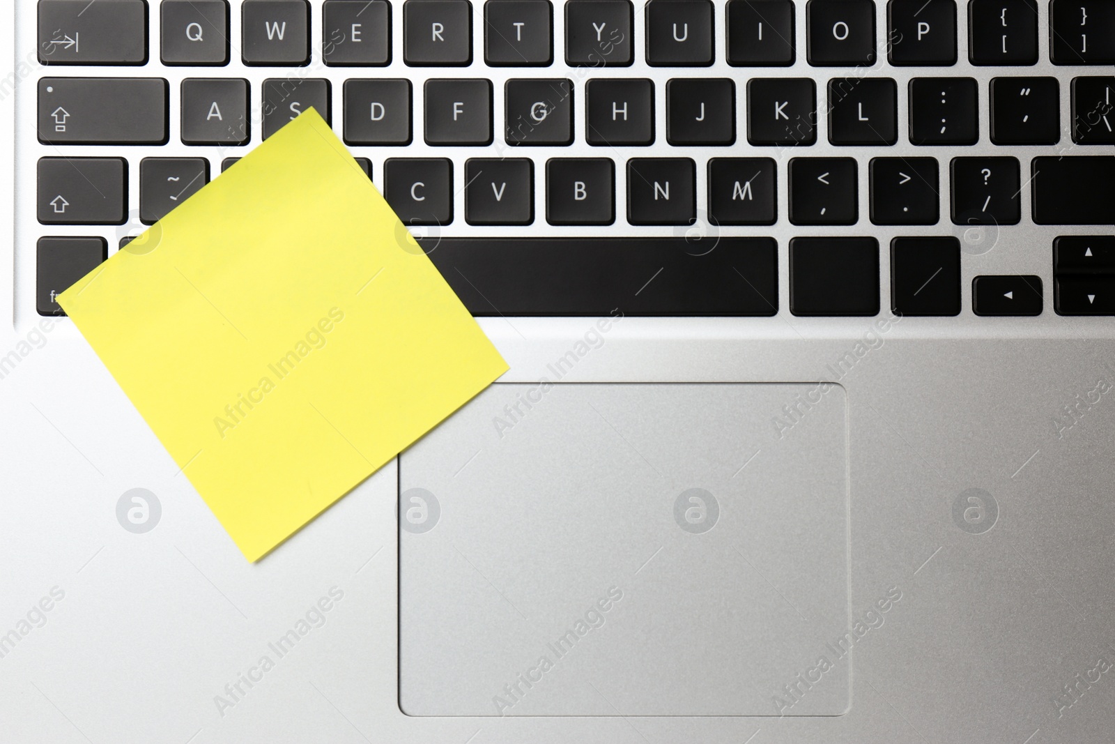 Photo of Blank sticky note on laptop, top view. Space for text