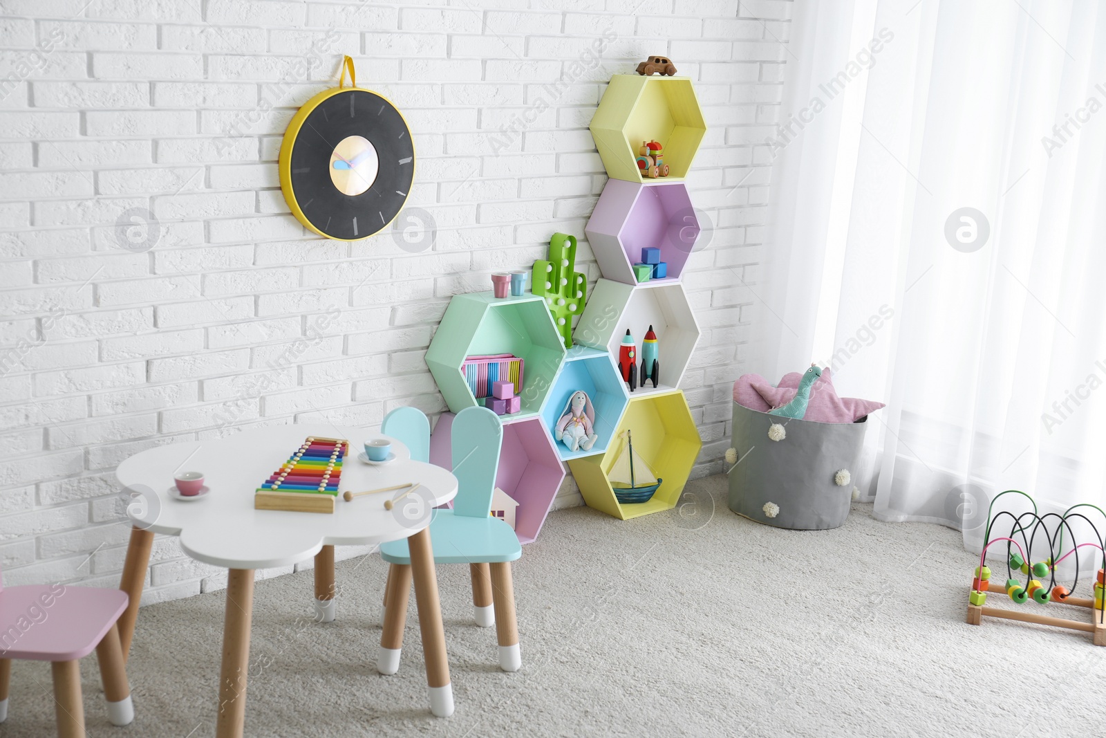 Photo of Child room interior with colorful shelves near brick wall