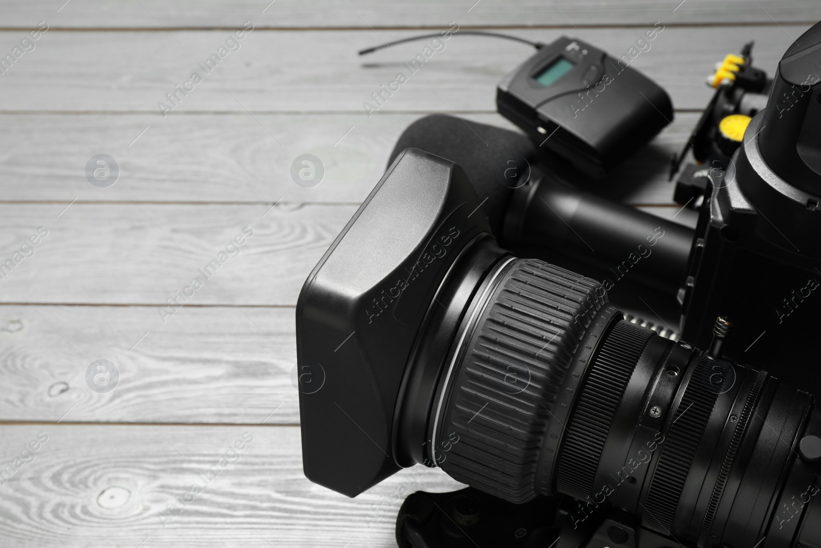 Photo of Camera and video production equipment on grey wooden background, closeup. Space for text