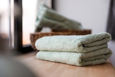 Photo of Clean soft towels on windowsill in bathroom