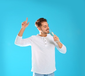 Portrait of happy man with champagne in glass on color background