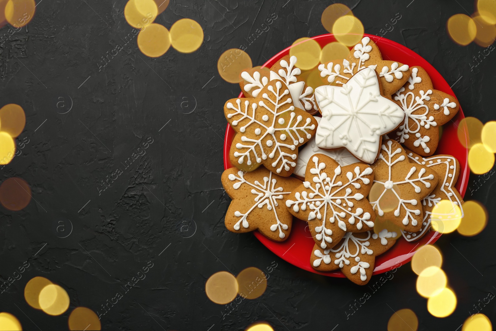 Photo of Tasty Christmas cookies with icing on black table, top view