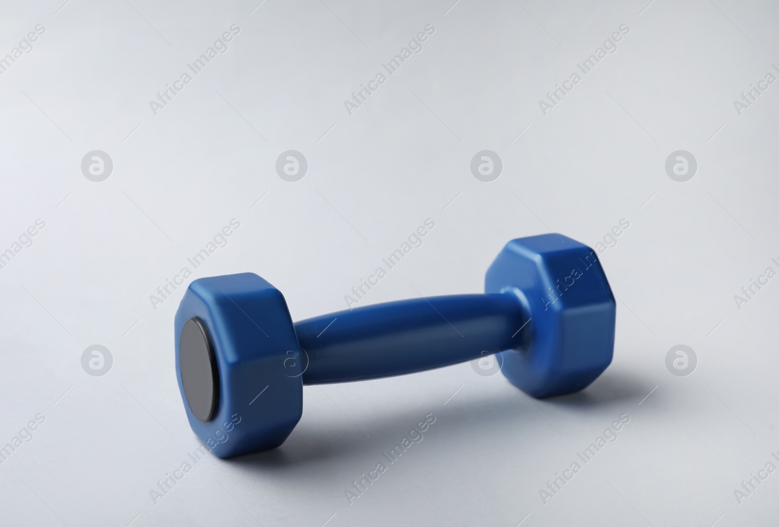 Photo of One new blue vinyl dumbbell on light background