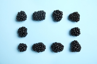 Flat lay composition with ripe blackberries on color background