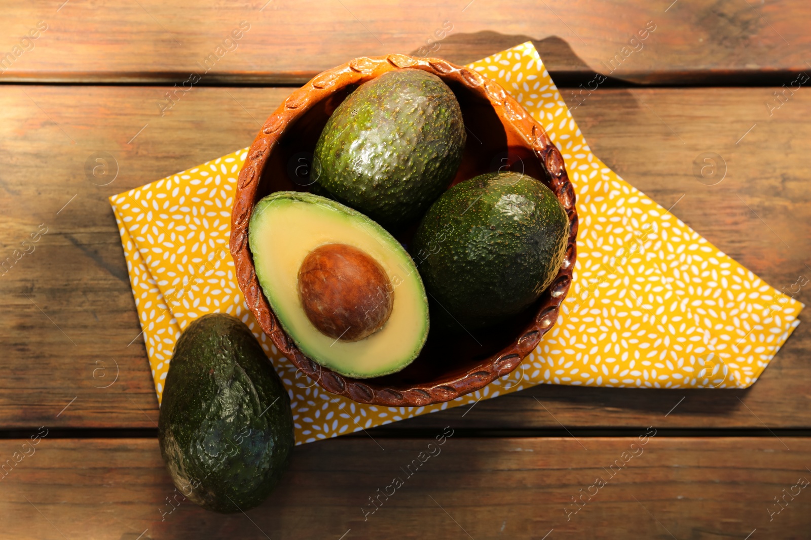 Photo of Tasty fresh avocados on wooden table, flat lay