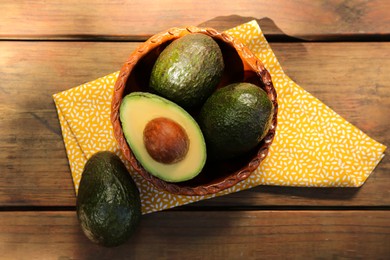Photo of Tasty fresh avocados on wooden table, flat lay
