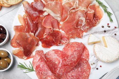 Tasty prosciutto served on light grey marble table, flat lay