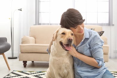 Adorable yellow labrador retriever with owner at home