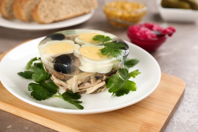 Delicious aspic with meat and vegetables served on grey table, closeup