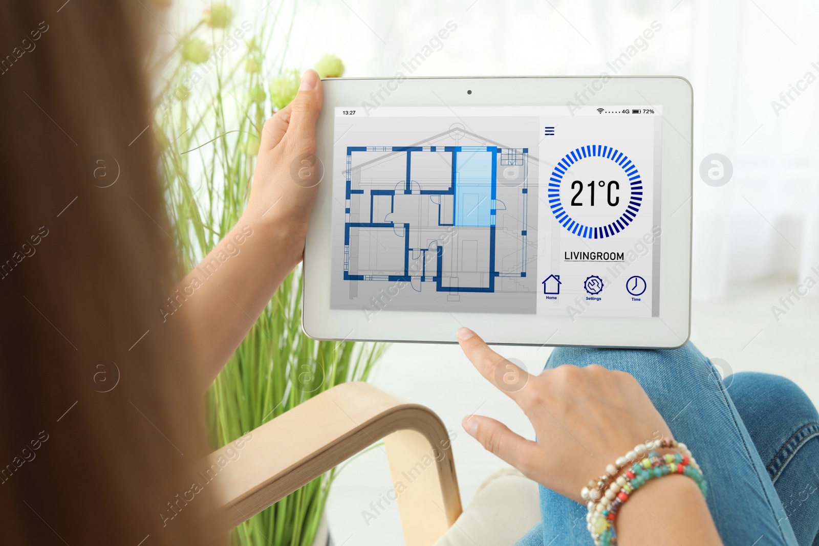 Image of Woman using tablet to control heating system in house, closeup