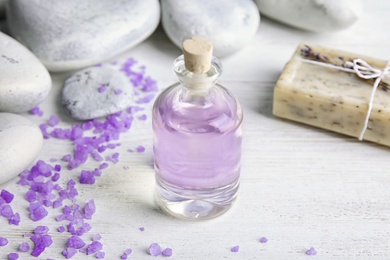 Bottle with natural lavender oil and soap on wooden background