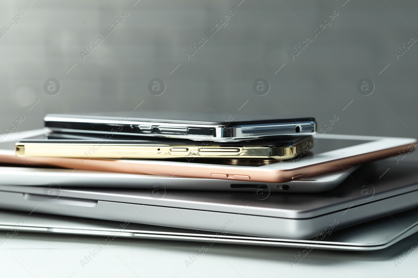 Photo of Stack of electronic devices on white table, closeup